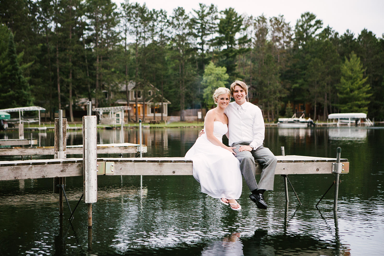 Couple sitting on the dock with feet in the water — barefoot and relaxed — Tim Larsen Photography, Brainerd Lakes MN