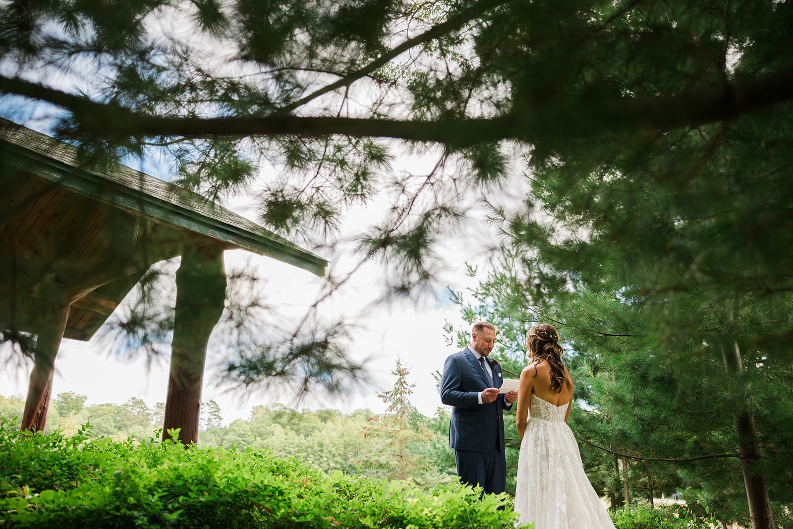 First look under the pine trees with the lodge roof behind them — Tim Larsen Photography, Brainerd Lakes MN