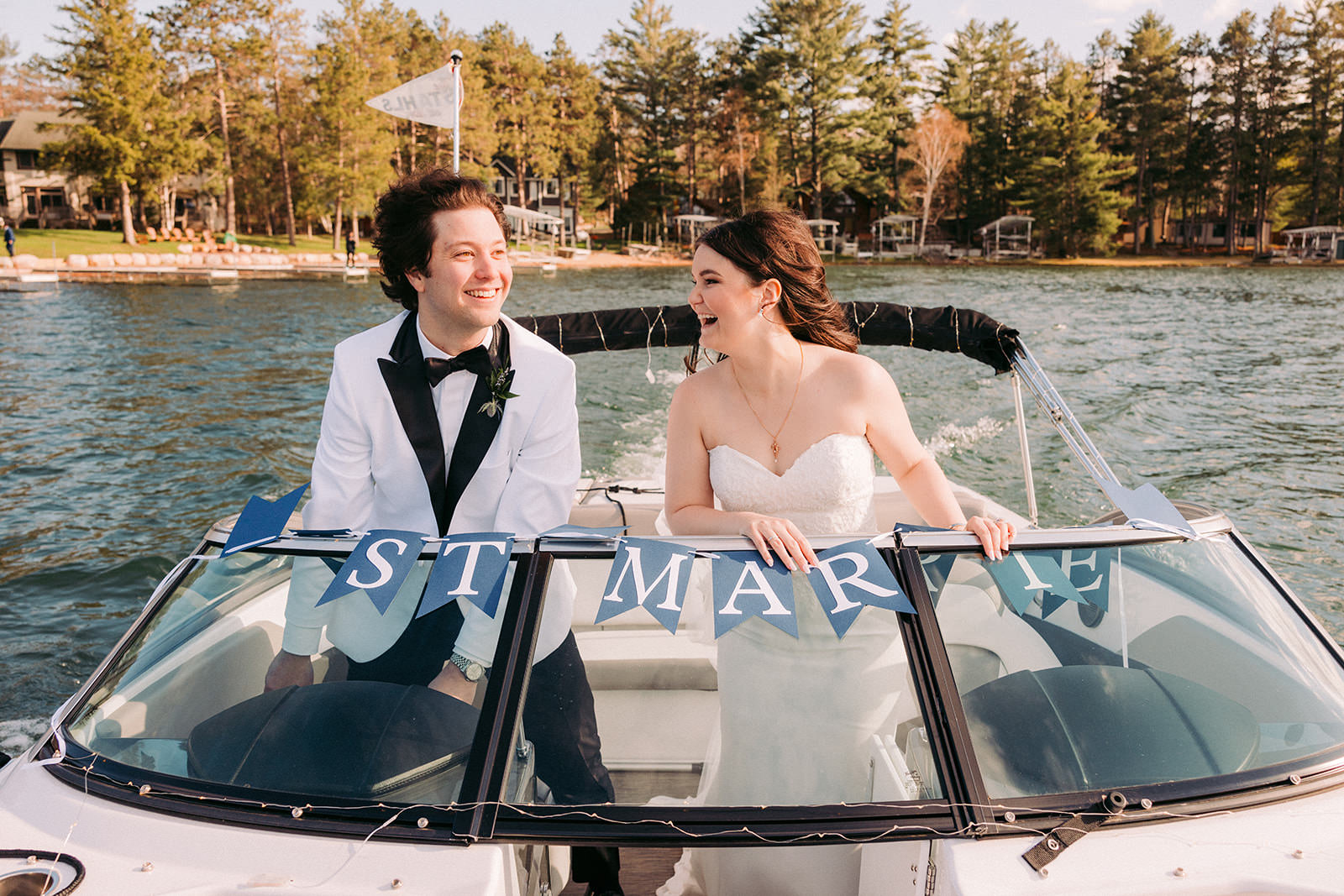 Couple in a boat on Big Trout Lake with ST MAR banner — spring wedding — Tim Larsen Photography, Brainerd Lakes MN