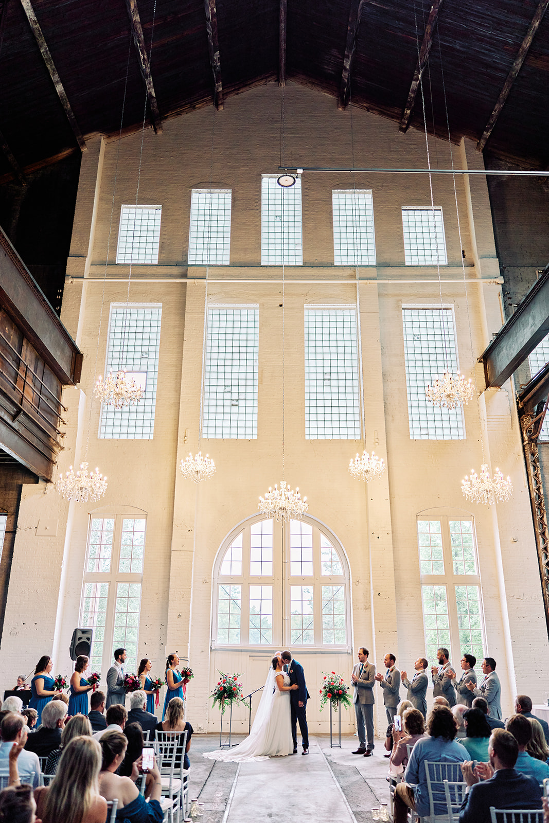 Ceremony in Three Main — towering windows, chandeliers, and industrial steel beams — Tim Larsen Photography, Brainerd Lakes MN