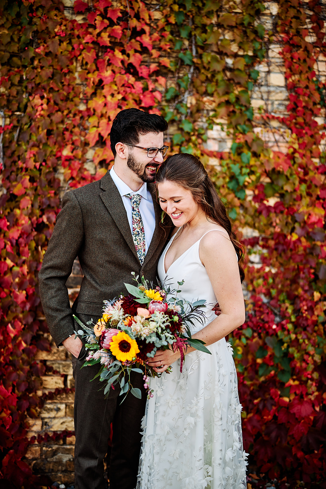Couple portrait against the red ivy wall — sunflower bouquet and tweed suit in fall — Tim Larsen Photography, Brainerd Lakes MN