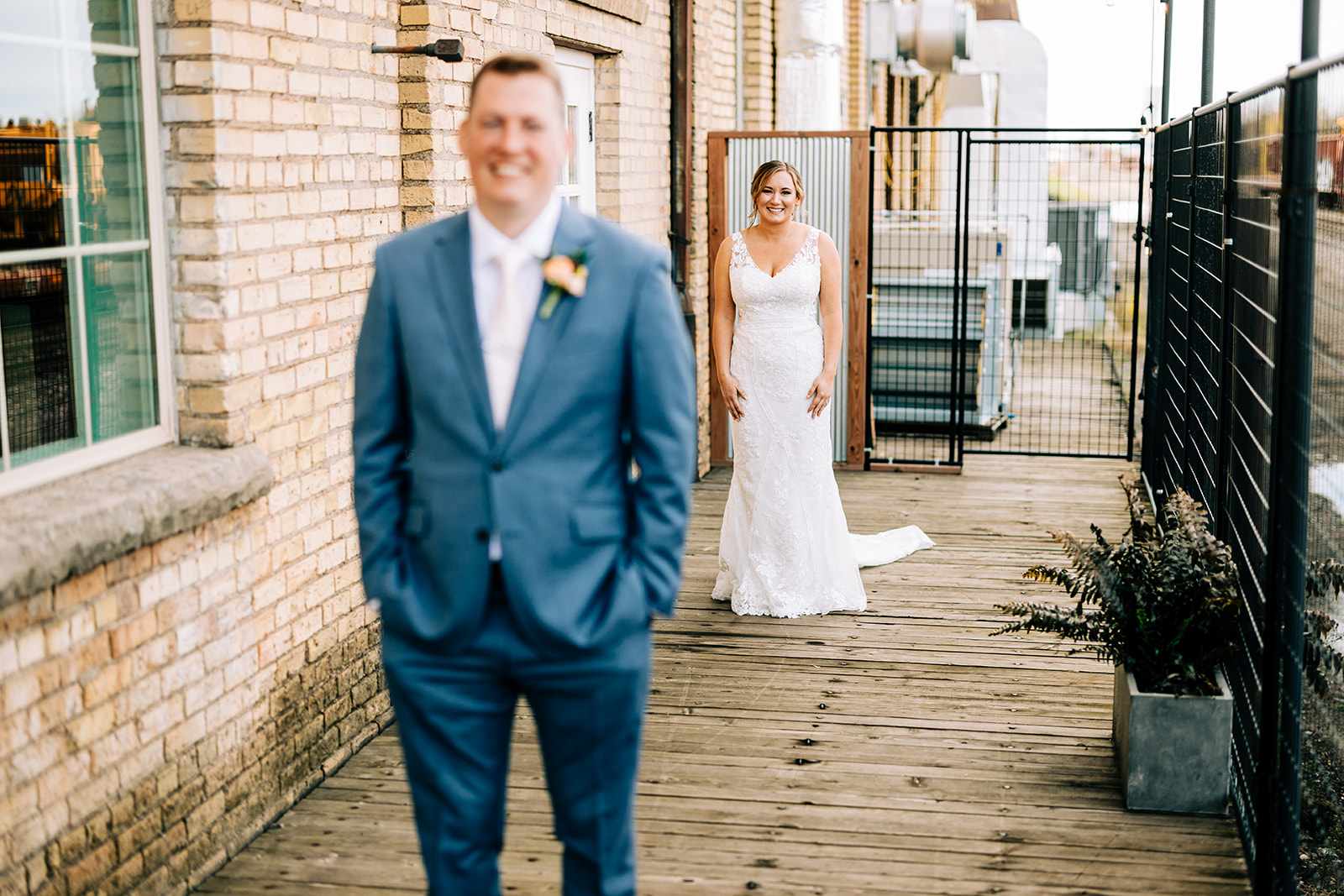 First look on the wooden deck — bride approaching groom from behind at Northern Pacific — Tim Larsen Photography, Brainerd Lakes MN