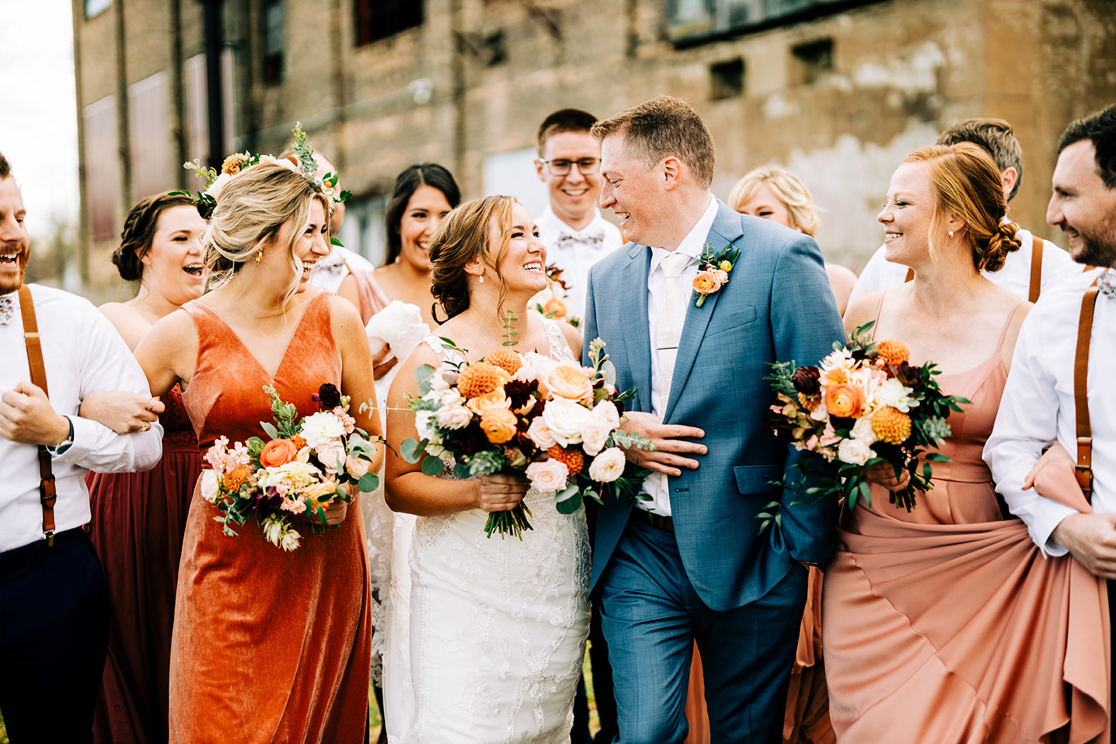 Wedding party laughing together outside the industrial building — rust and copper tones — Tim Larsen Photography, Brainerd Lakes MN