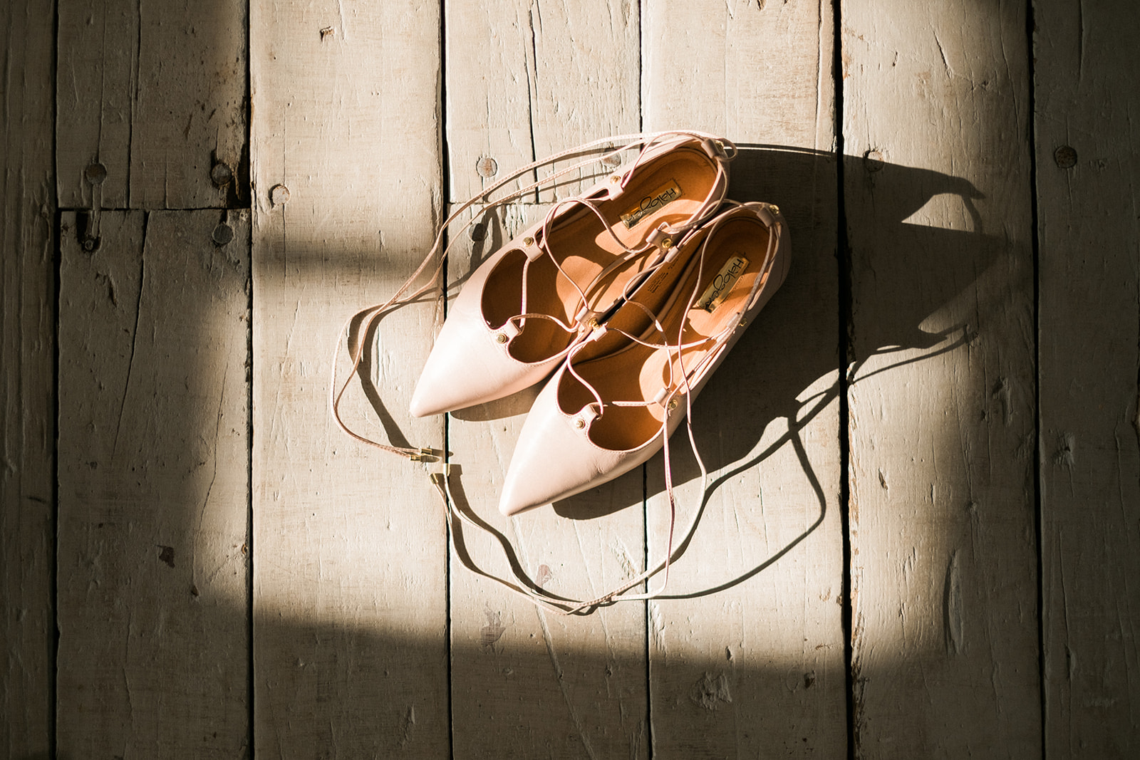 Bridal shoes in a shaft of light on the wooden floor — detail shot — Tim Larsen Photography, Brainerd Lakes MN