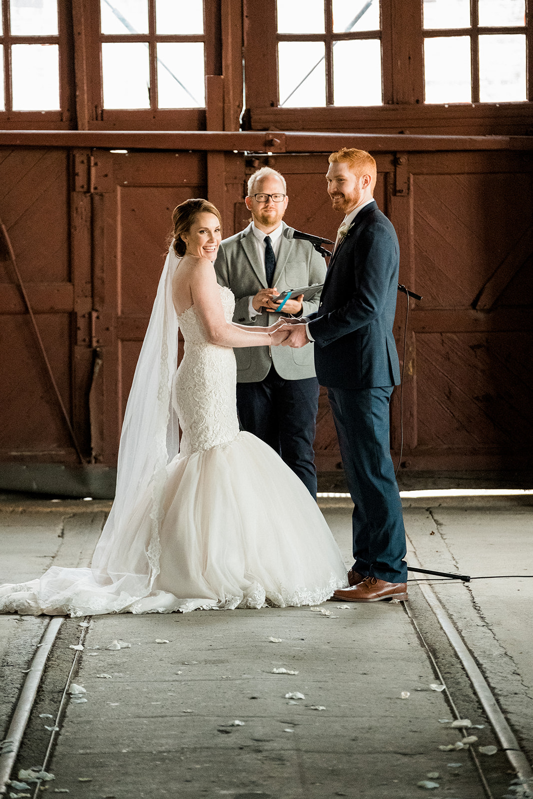 Ceremony on the railroad tracks inside the industrial hall — intimate gathering — Tim Larsen Photography, Brainerd Lakes MN