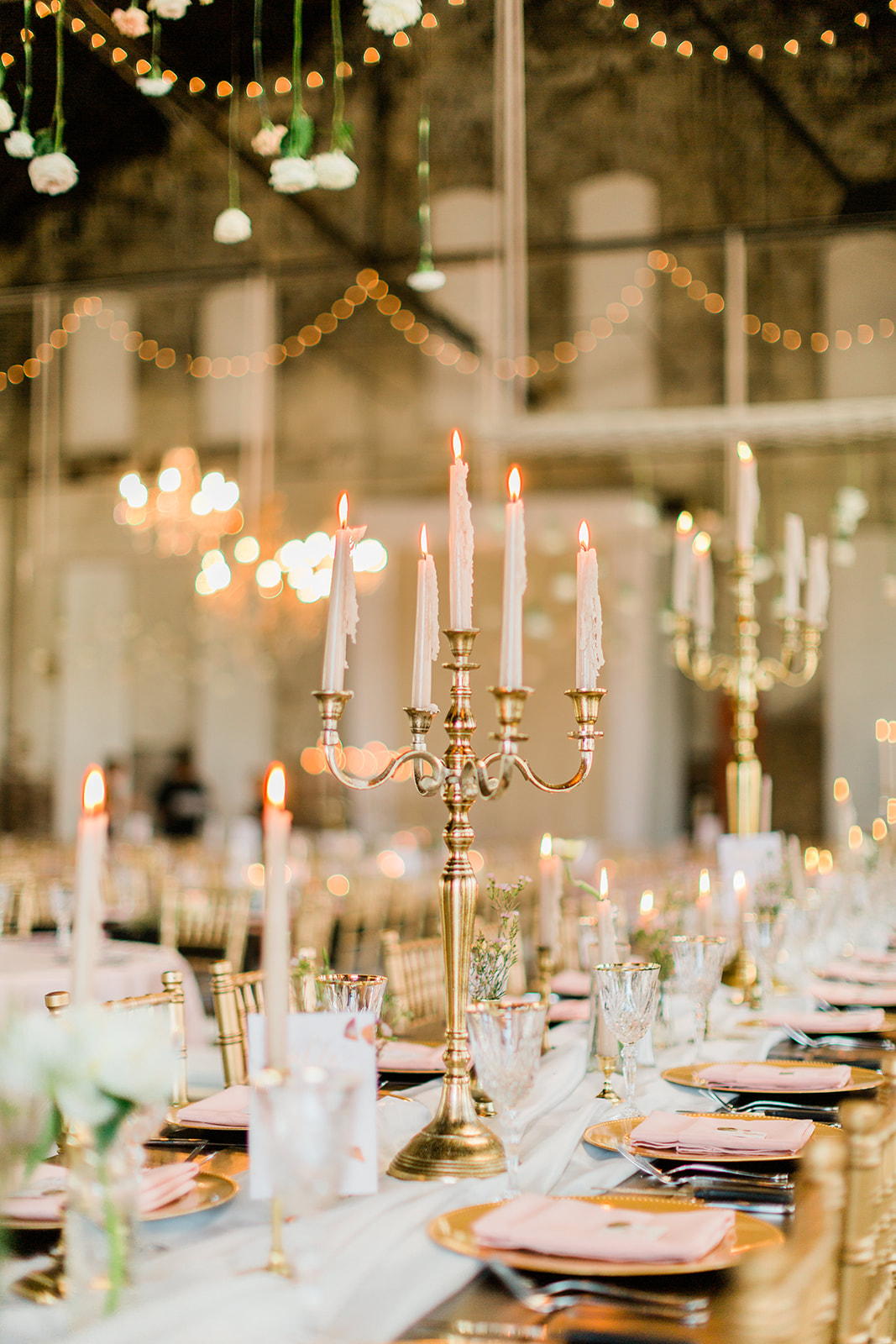 Gold candelabra centerpiece with taper candles and pink napkins — reception detail — Tim Larsen Photography, Brainerd Lakes MN