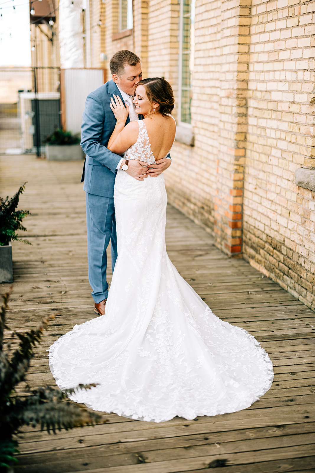 Couple portrait on the wooden deck — lace train and brick wall behind — Tim Larsen Photography, Brainerd Lakes MN