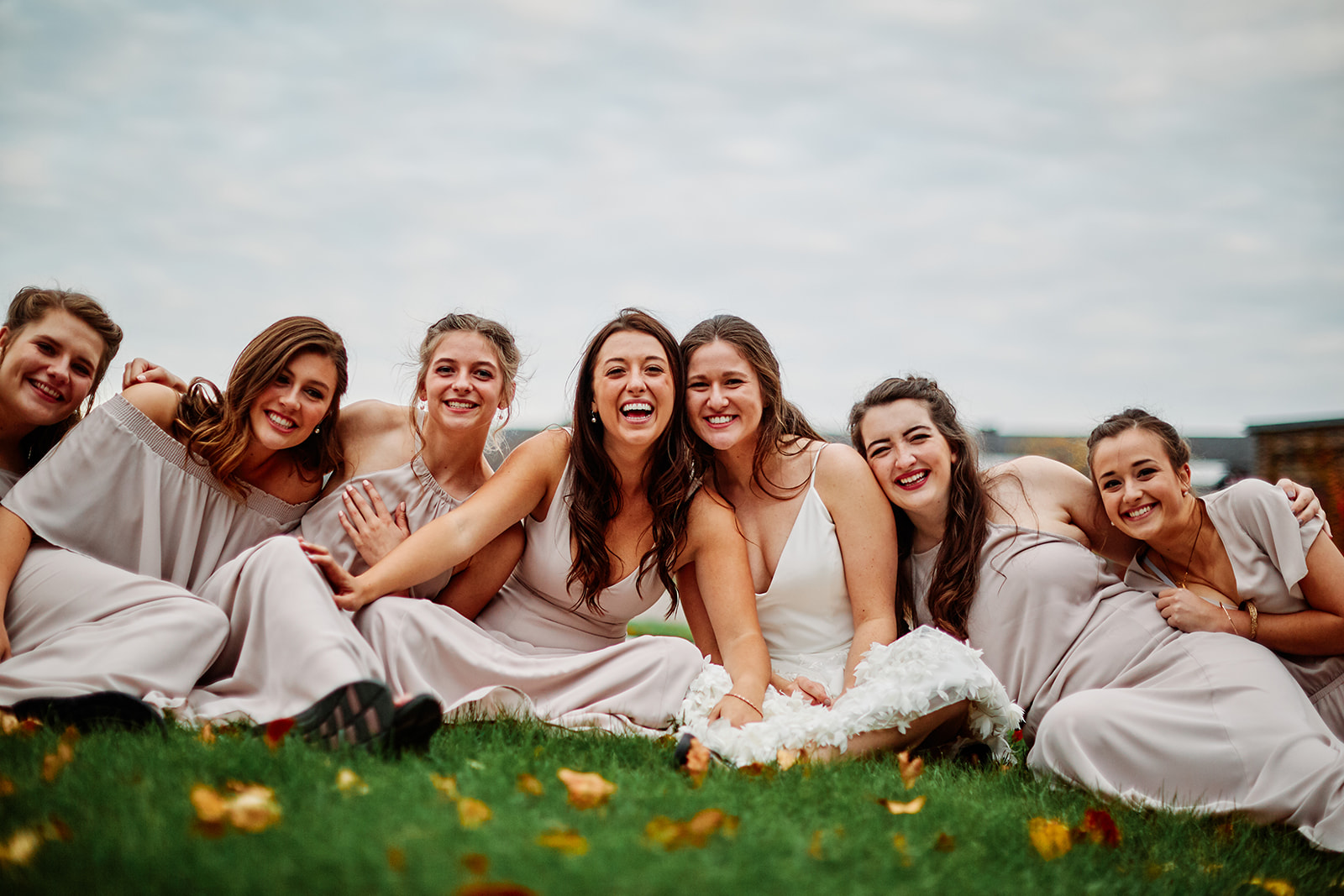 Bridesmaids lying on the grass laughing — candid group shot on the lawn — Tim Larsen Photography, Brainerd Lakes MN