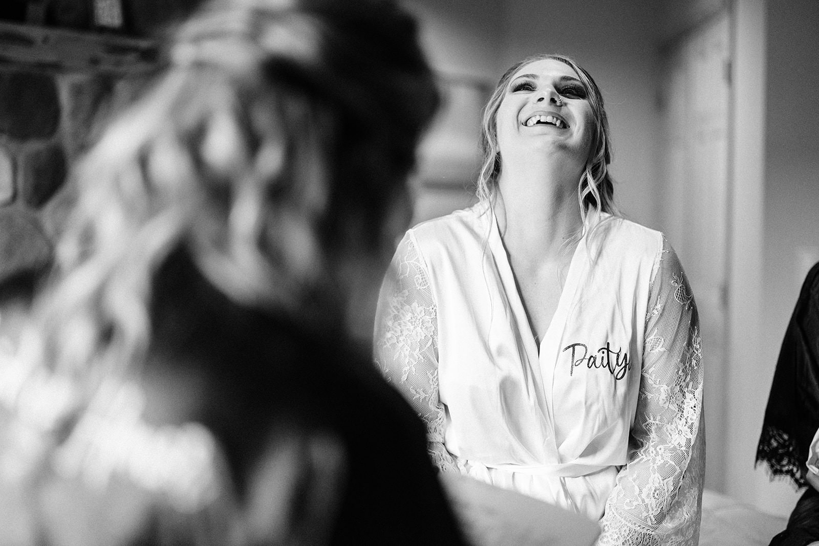 Bridesmaid laughing in a personalized lace robe — getting ready in black and white — Tim Larsen Photography, Brainerd Lakes MN