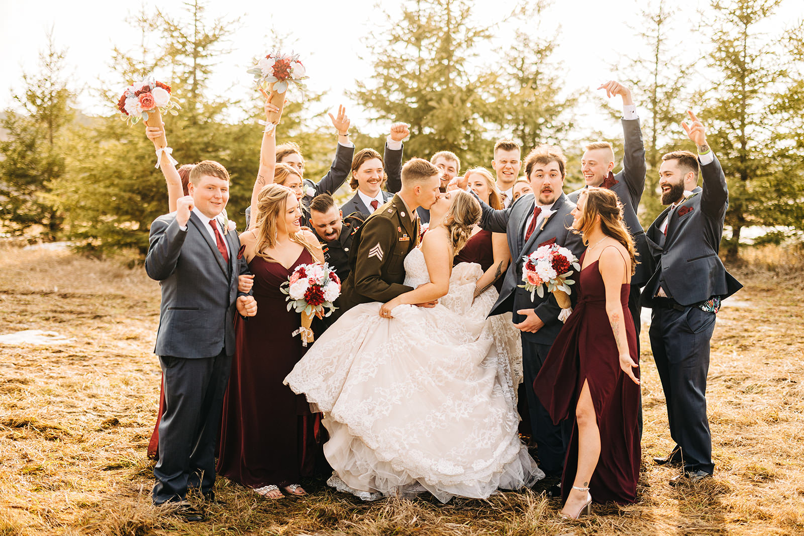 Full wedding party cheering as couple kisses — fall field at Pine Peaks — Tim Larsen Photography, Brainerd Lakes MN