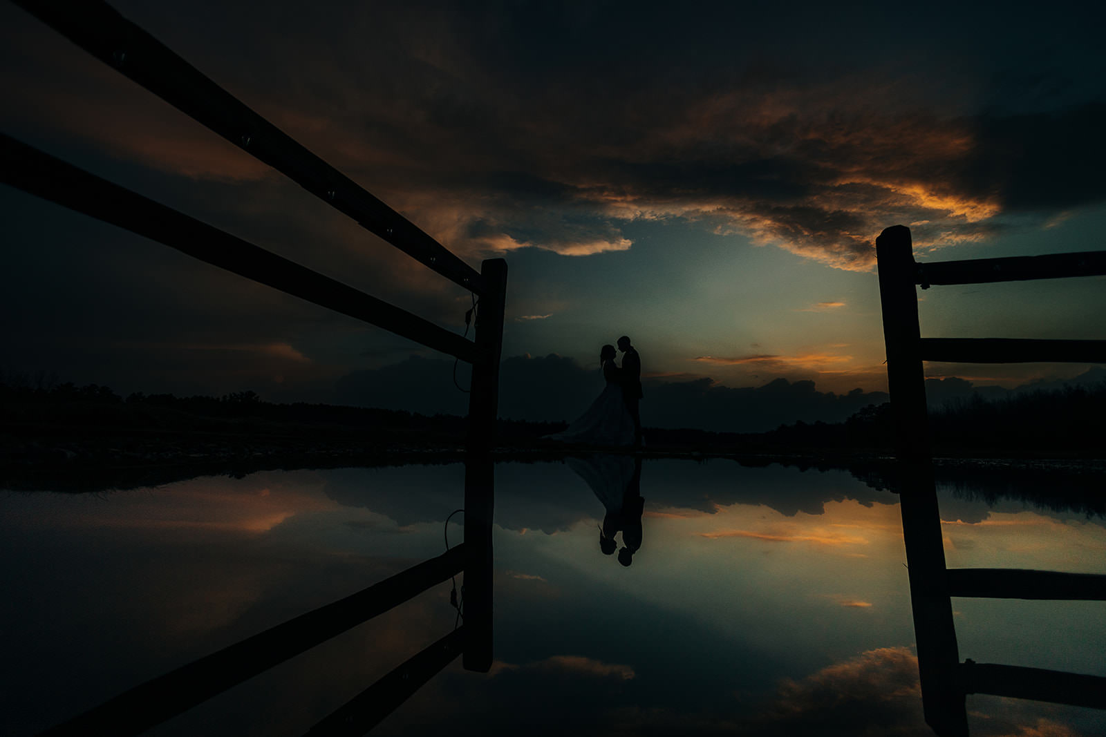 Couple silhouette by the fence with dramatic sunset reflection at Pine Peaks — Tim Larsen Photography, Brainerd Lakes MN