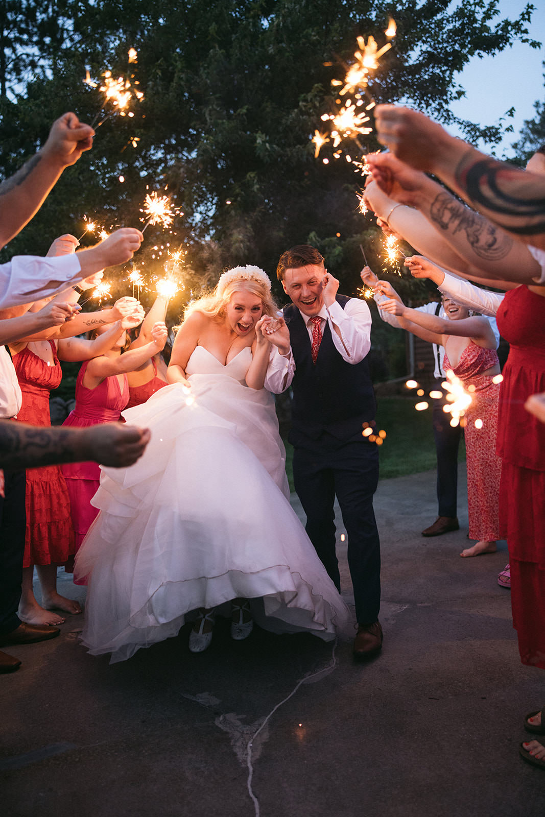 Sparkler send-off with guests cheering — couple running through sparklers at Pine Peaks — Tim Larsen Photography, Brainerd Lakes MN