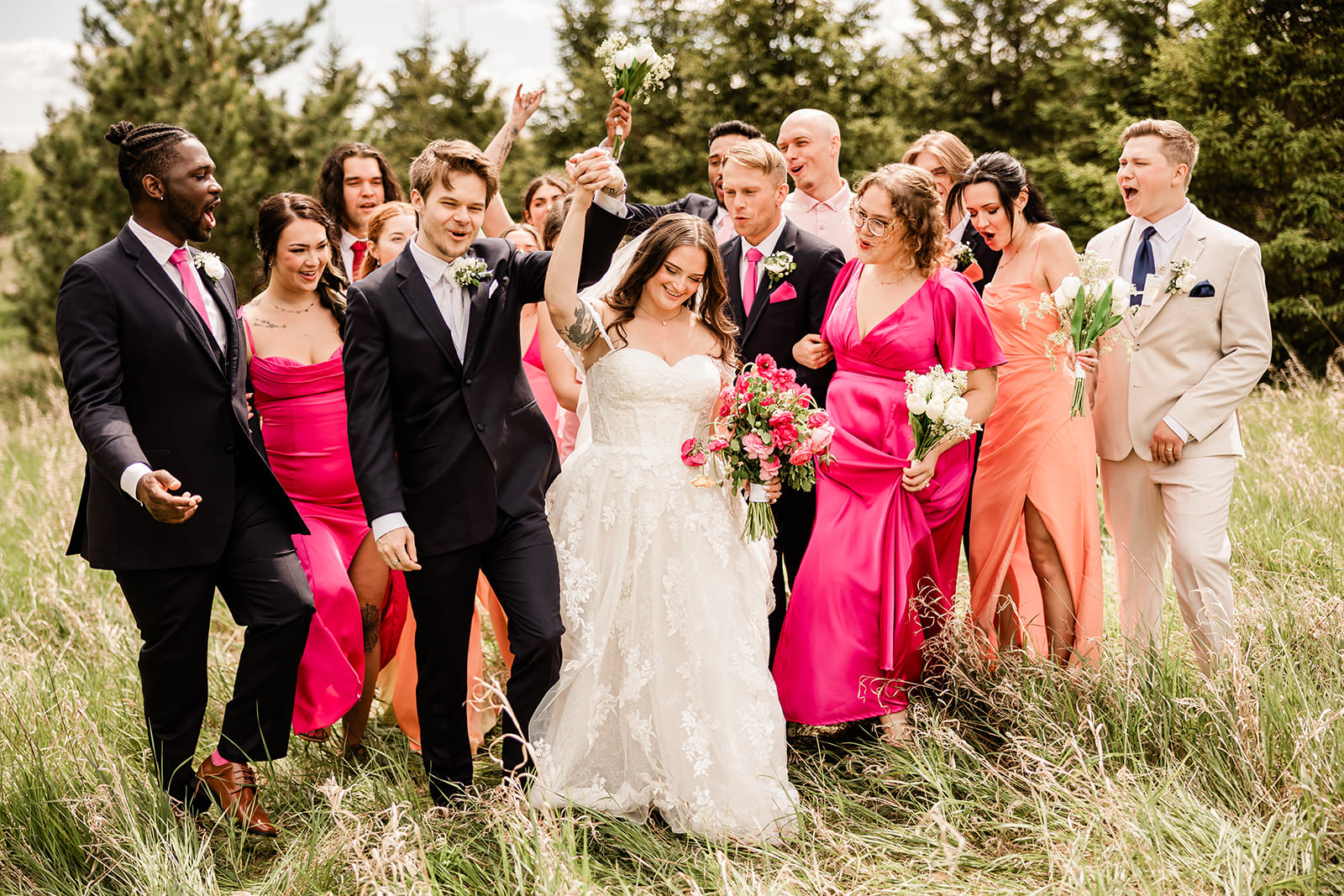 Wedding party walking through the tall grass field — hot pink and mismatched dresses — Tim Larsen Photography, Brainerd Lakes MN
