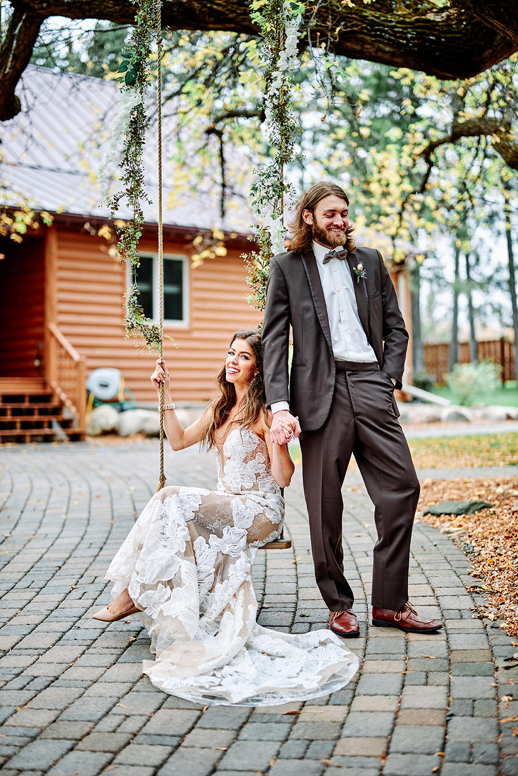 Couple on the tree swing with fall color and the lodge behind — boho styled — Tim Larsen Photography, Brainerd Lakes MN