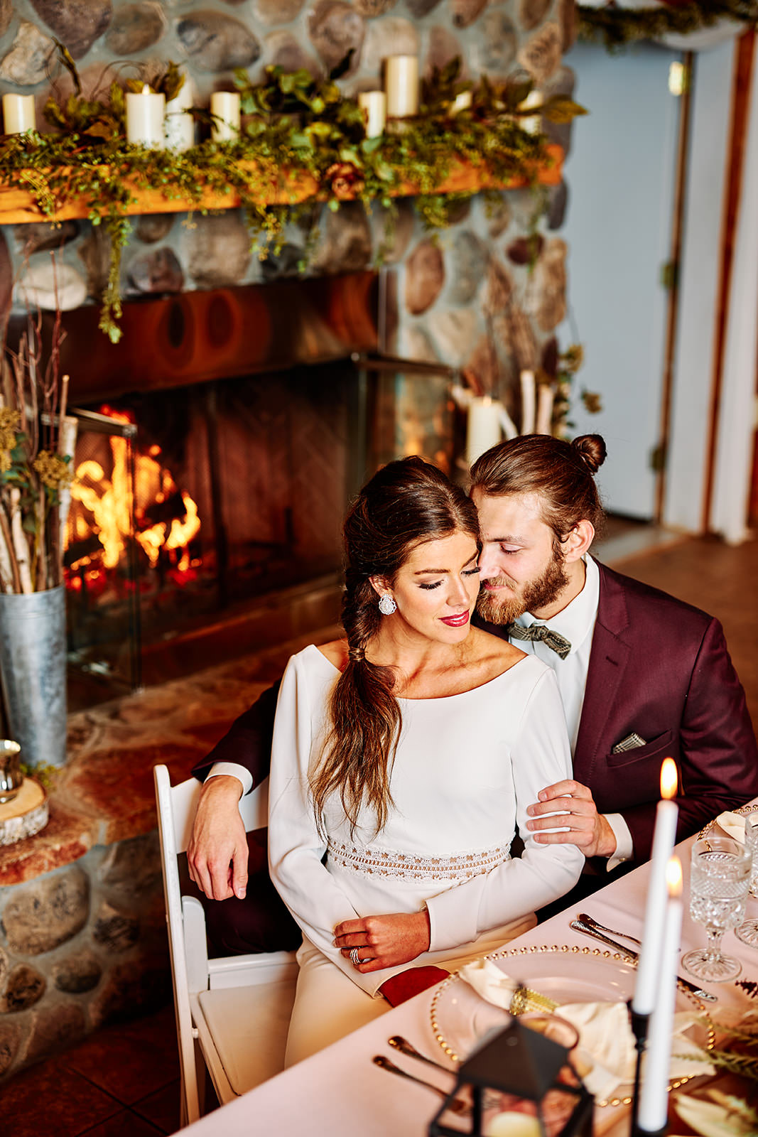 Couple embracing by the fireplace with candles and fall tablescape — intimate reception — Tim Larsen Photography, Brainerd Lakes MN