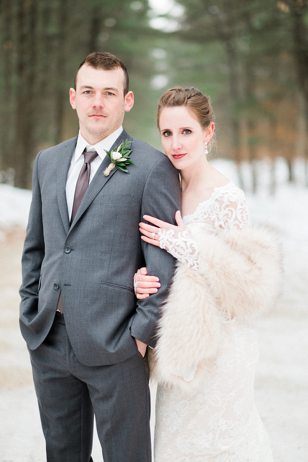 Winter wedding portrait — couple in fur stole and gray suit with snowy pines — Tim Larsen Photography, Brainerd Lakes MN