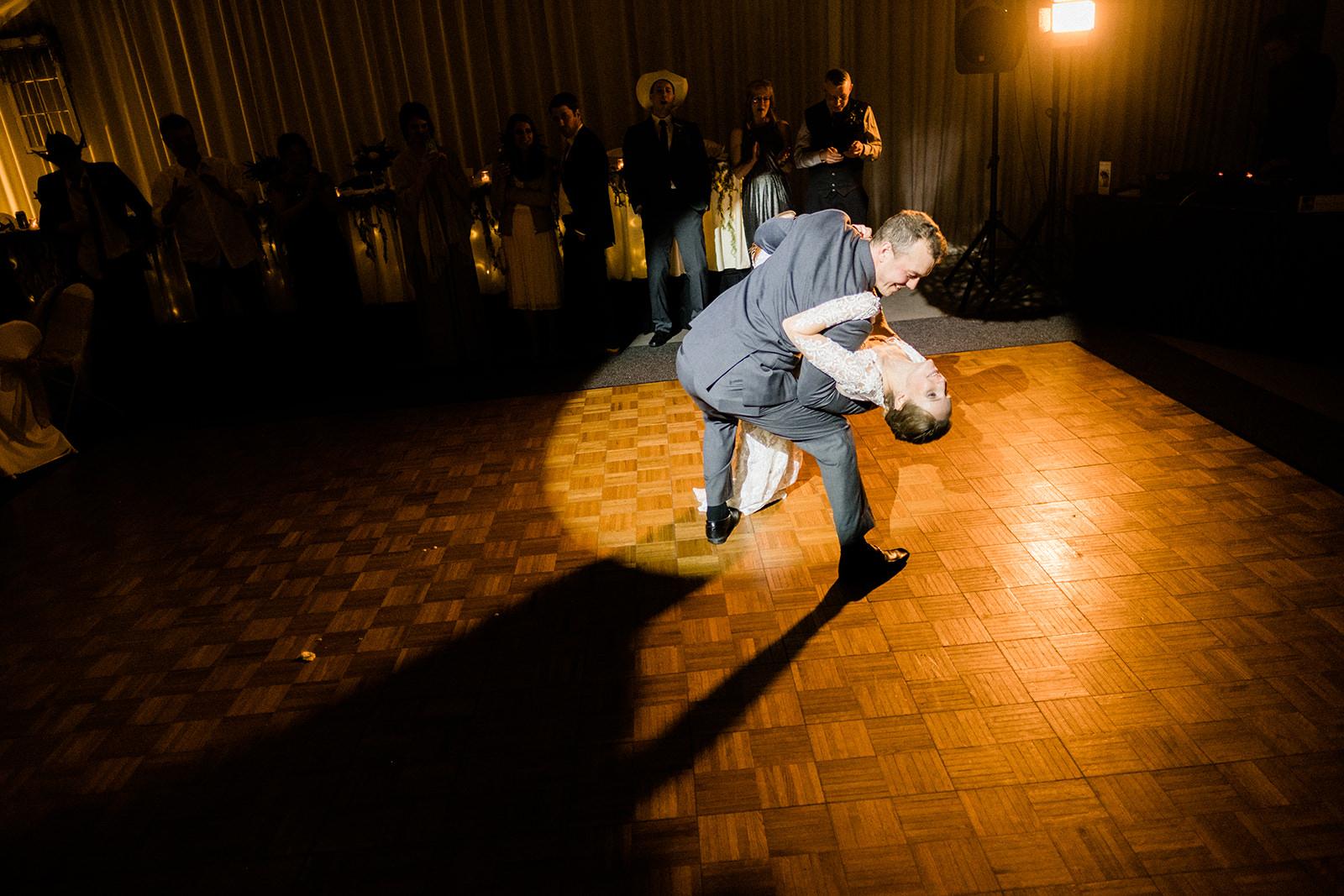Groom dipping bride on the dance floor in spotlight — winter reception at Pine Peaks — Tim Larsen Photography, Brainerd Lakes MN