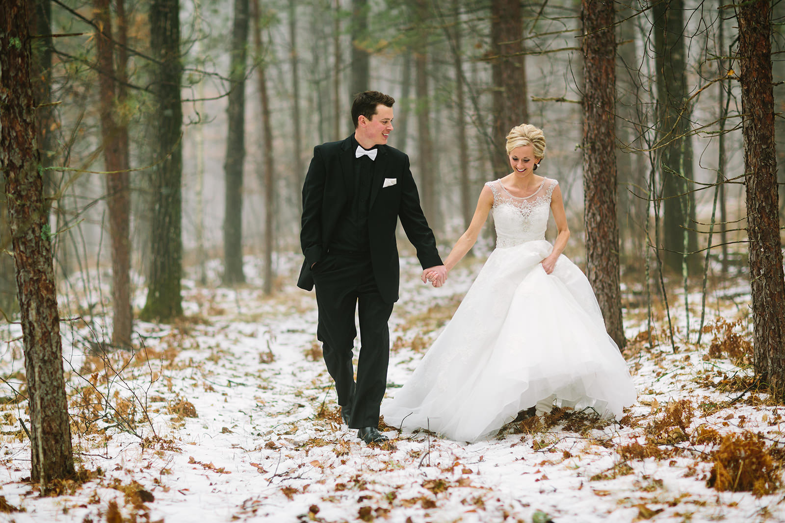 Winter couple portrait walking hand in hand through the snowy pine forest — Tim Larsen Photography, Brainerd Lakes MN