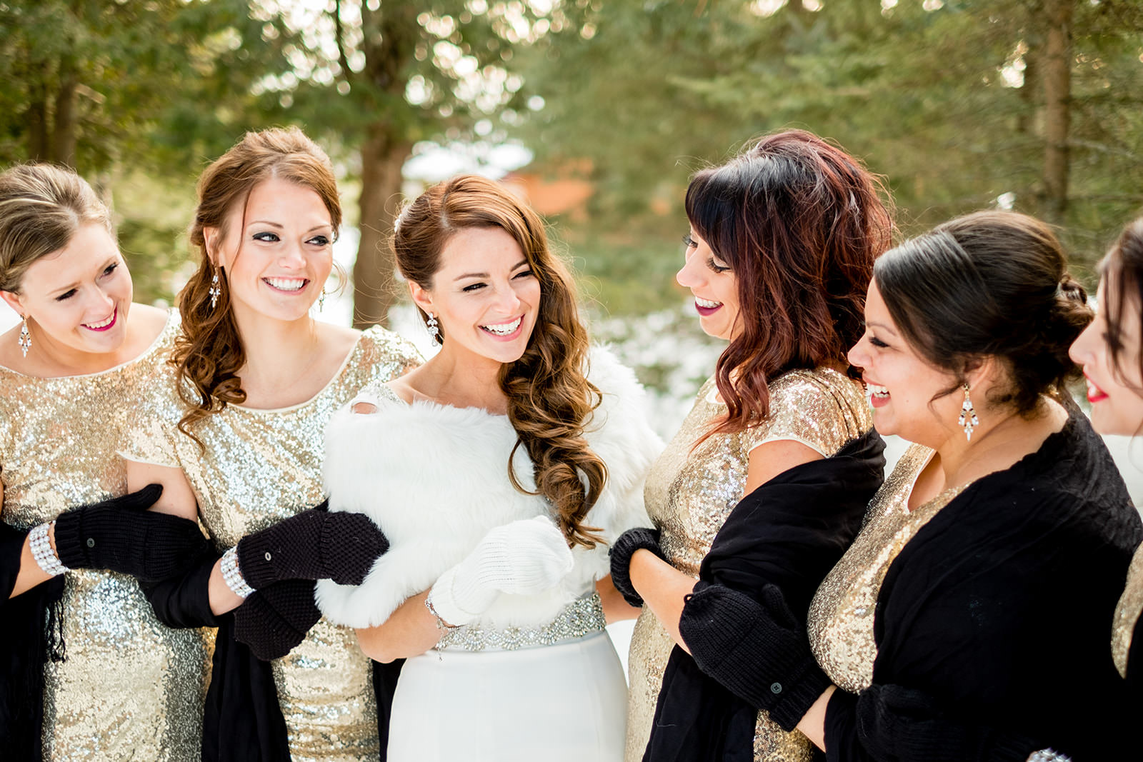 Bride laughing with bridesmaids in gold sequin dresses and fur wraps in the snow — Tim Larsen Photography, Brainerd Lakes MN