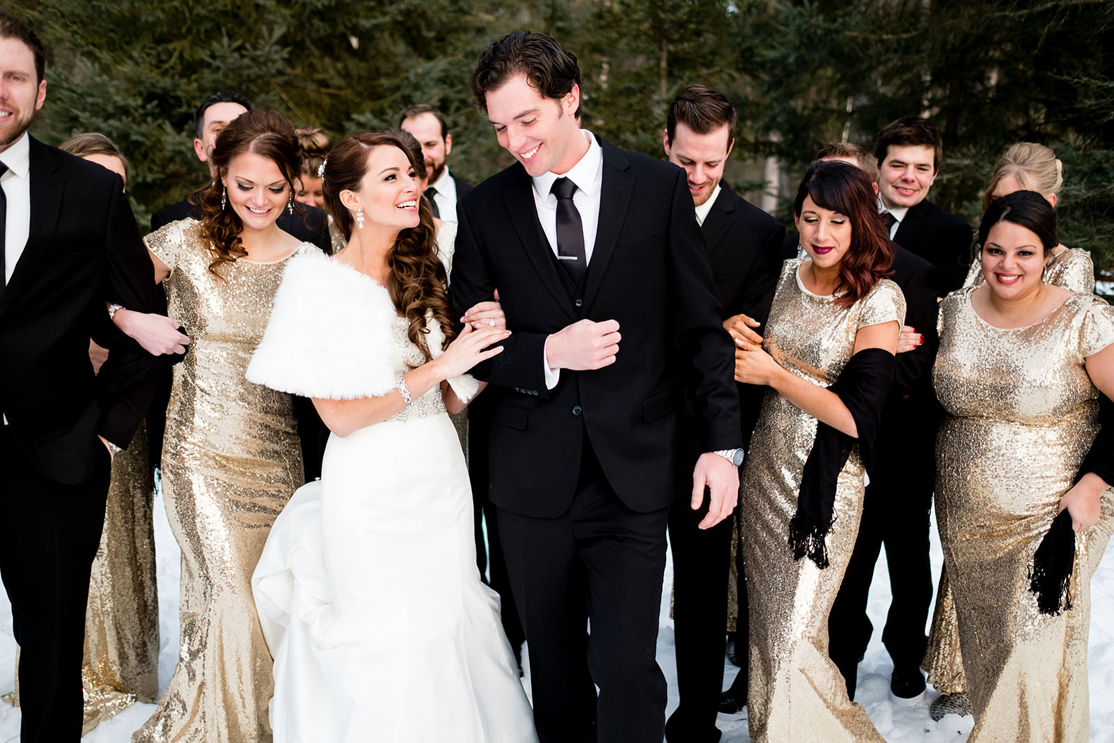 Couple with wedding party in gold sequin dresses walking through the snow — Tim Larsen Photography, Brainerd Lakes MN