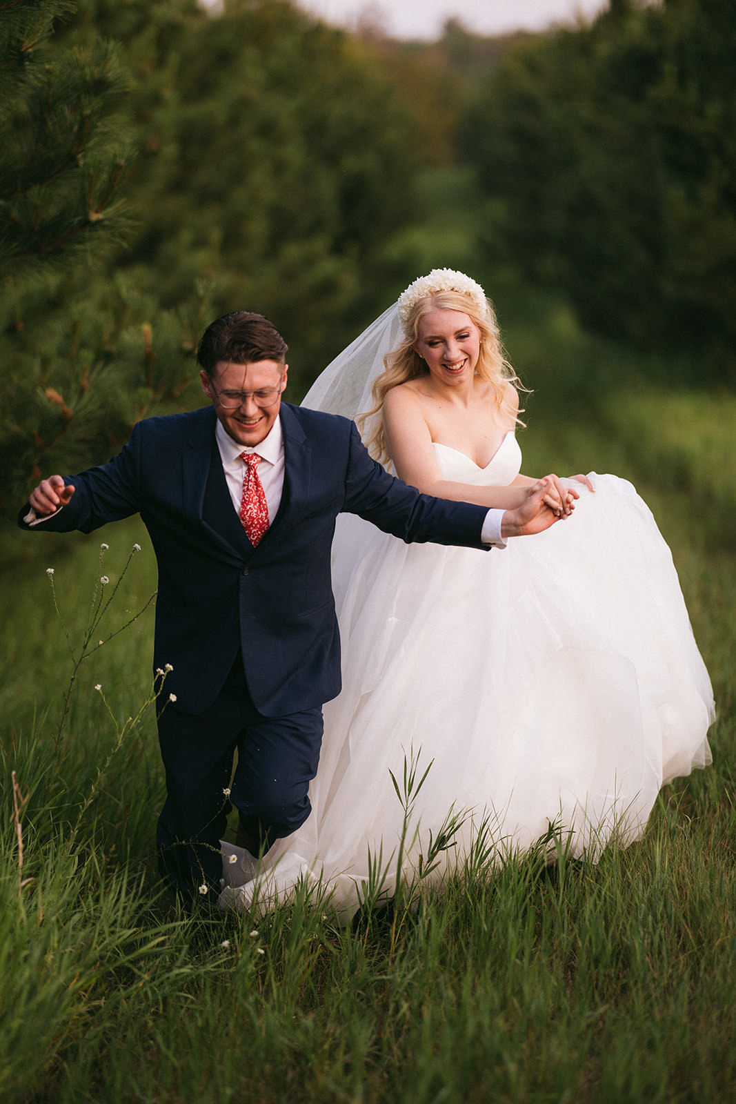 Couple running through the tall grass laughing at golden hour — Tim Larsen Photography, Brainerd Lakes MN