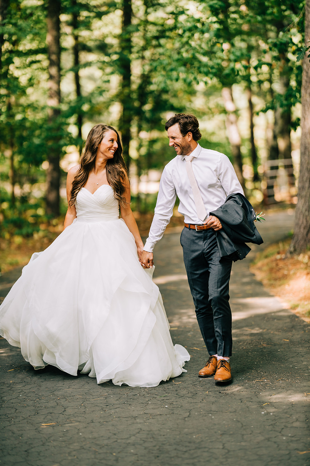 Couple walking and smiling on a sunlit wooded path — Tim Larsen Photography, Brainerd Lakes MN