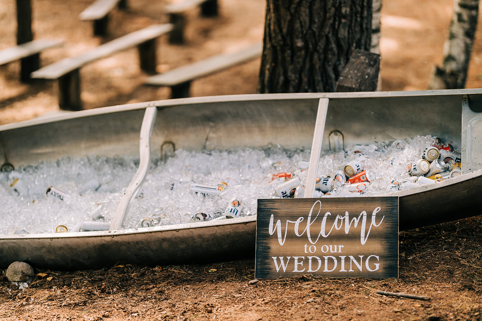 Canoe filled with ice and drinks beside a welcome-to-our-wedding sign — Tim Larsen Photography, Brainerd Lakes MN