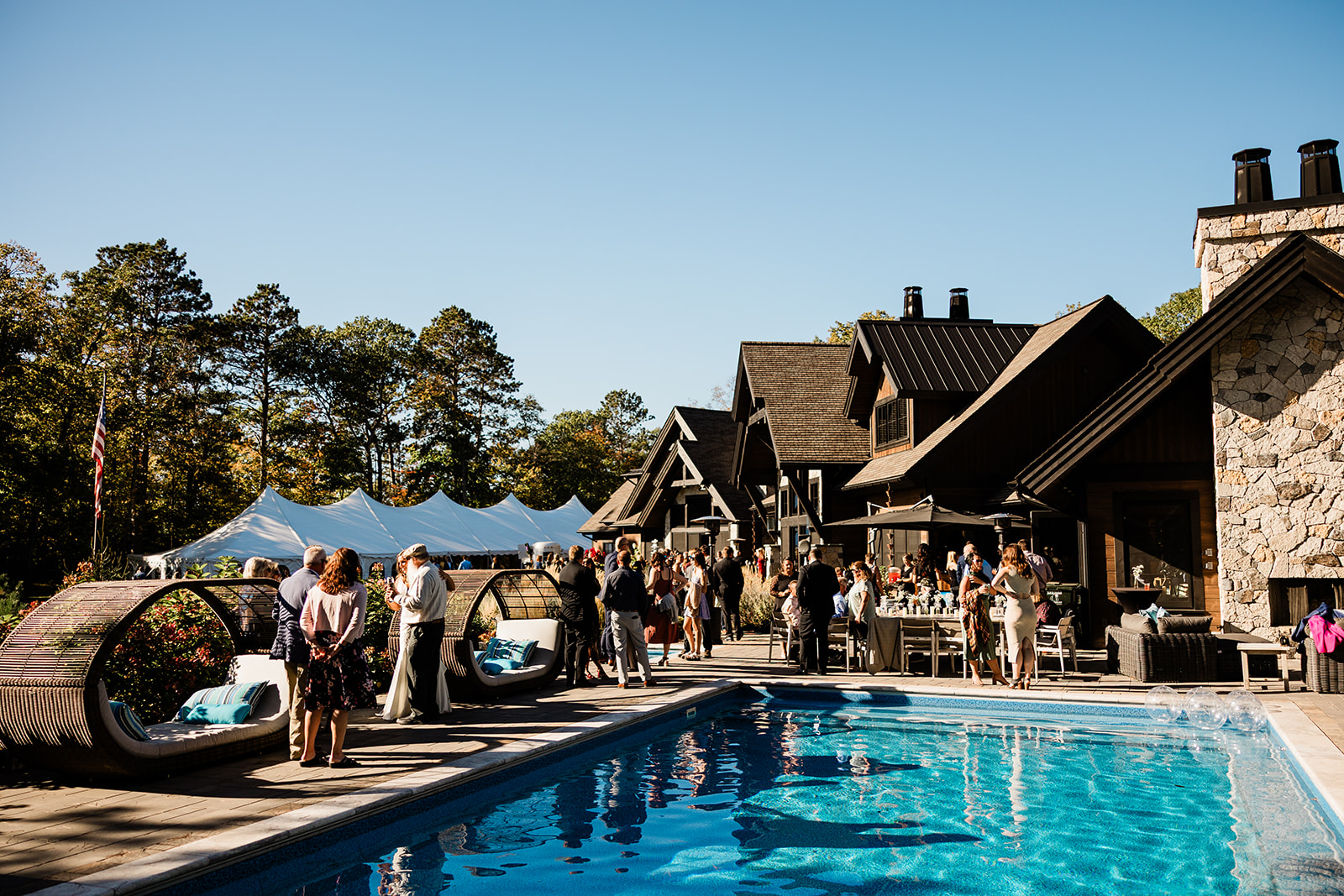 Cocktail hour by the pool at a stone-and-timber lakeside estate — Tim Larsen Photography, Brainerd Lakes MN