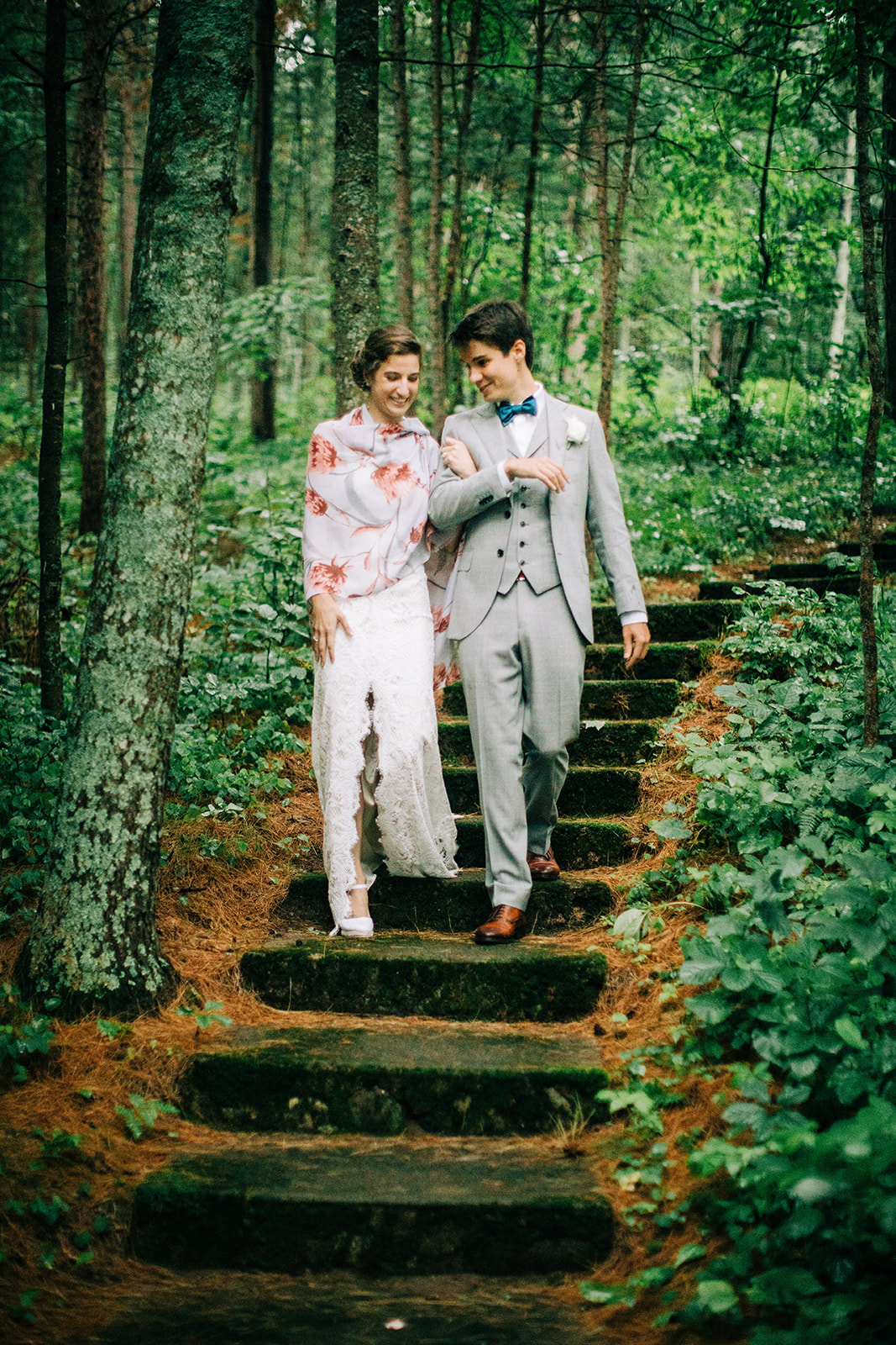 Couple descending mossy stone steps through a lush green forest — Tim Larsen Photography, Brainerd Lakes MN