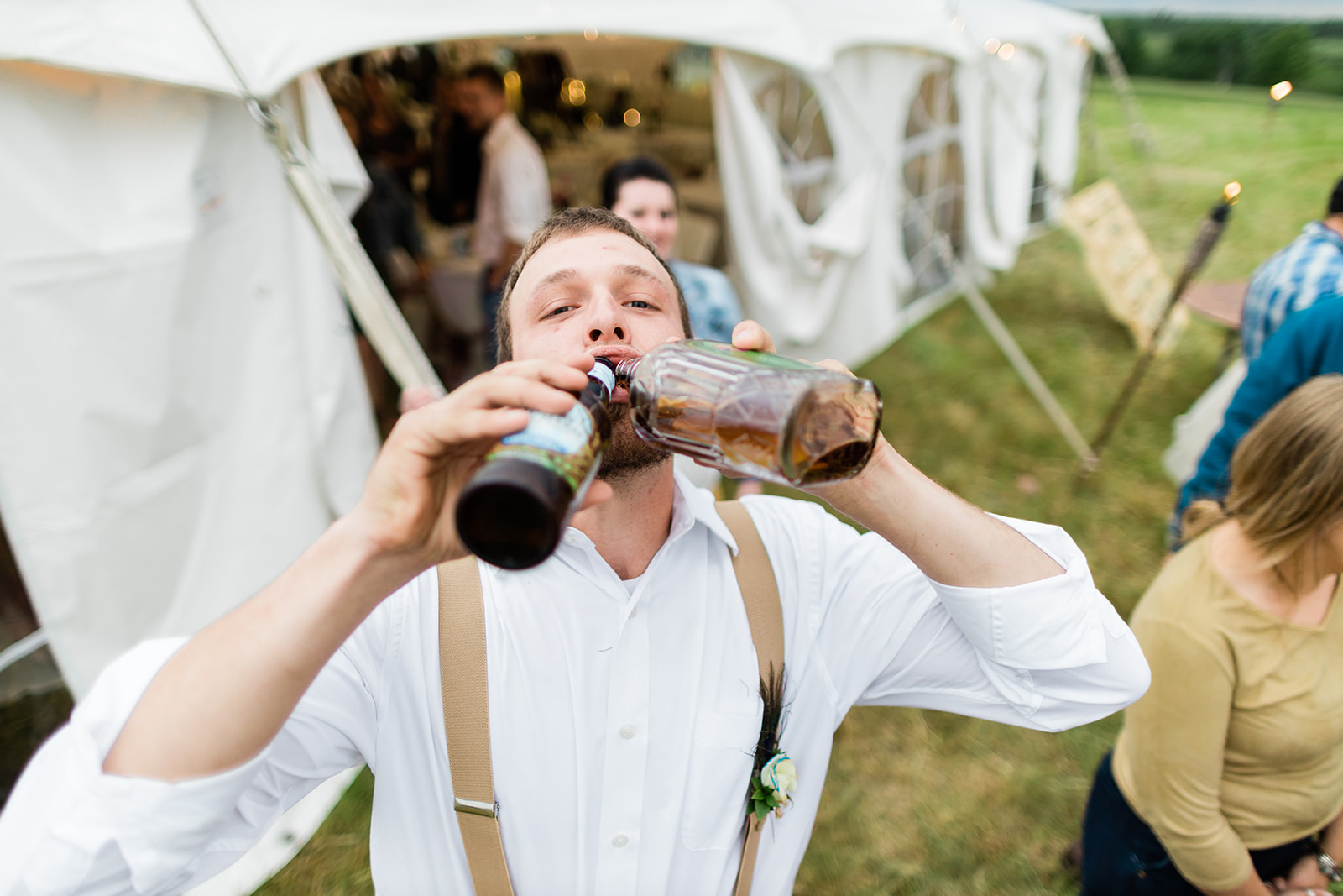 Groomsman with a drink outside the reception tent on the lawn — Tim Larsen Photography, Brainerd Lakes MN
