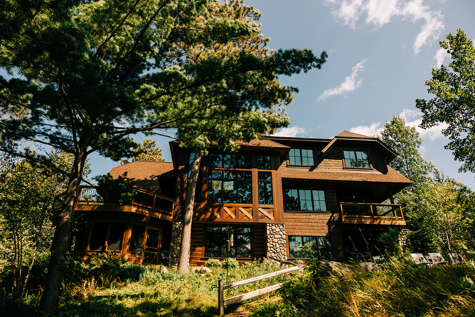 Modern timber-and-stone lake home nestled among tall pine trees — Tim Larsen Photography, Brainerd Lakes MN