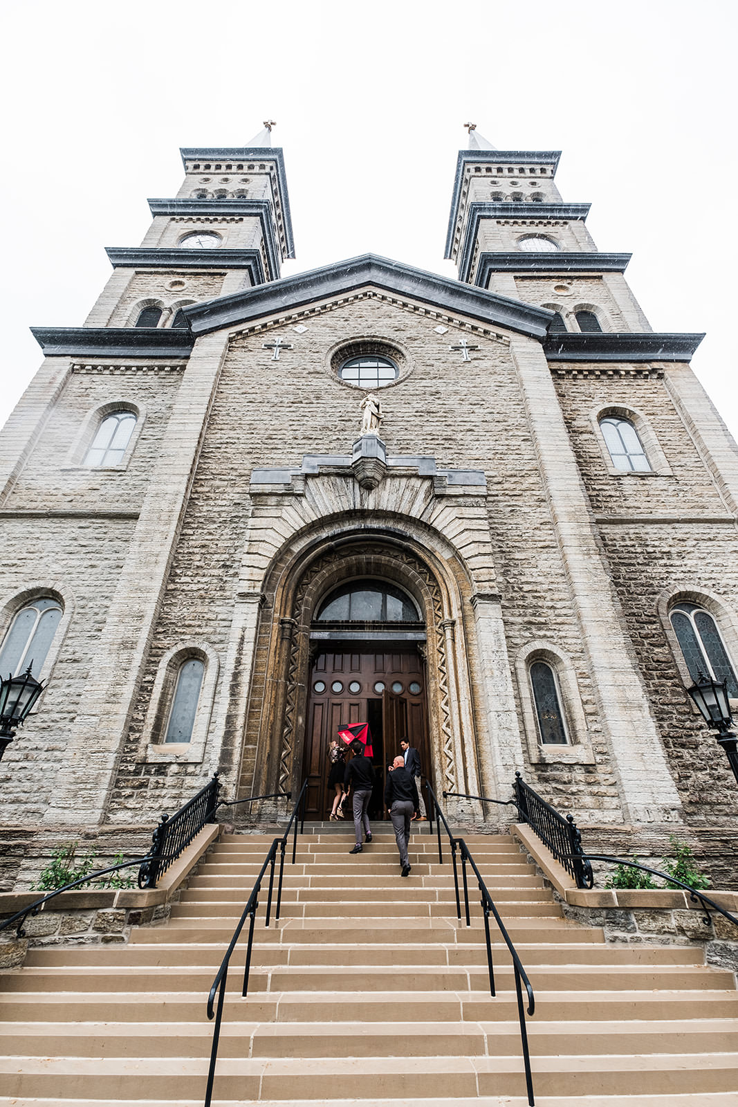 Historic stone church exterior with bell towers — Minneapolis cathedral wedding — Tim Larsen Photography, Brainerd Lakes MN