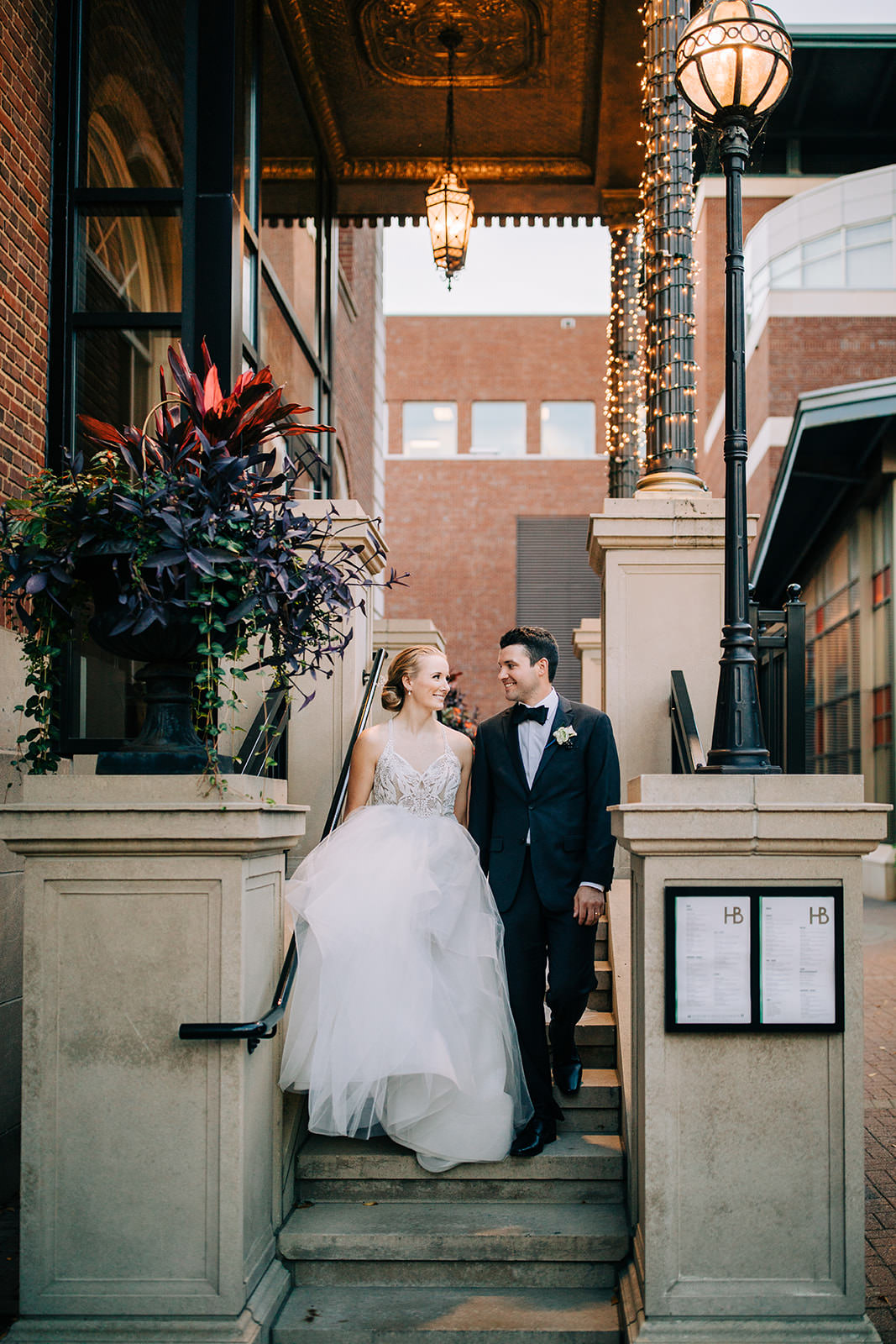 Couple on the steps of a downtown Minneapolis restaurant with string lights at golden hour — Tim Larsen Photography, Brainerd Lakes MN