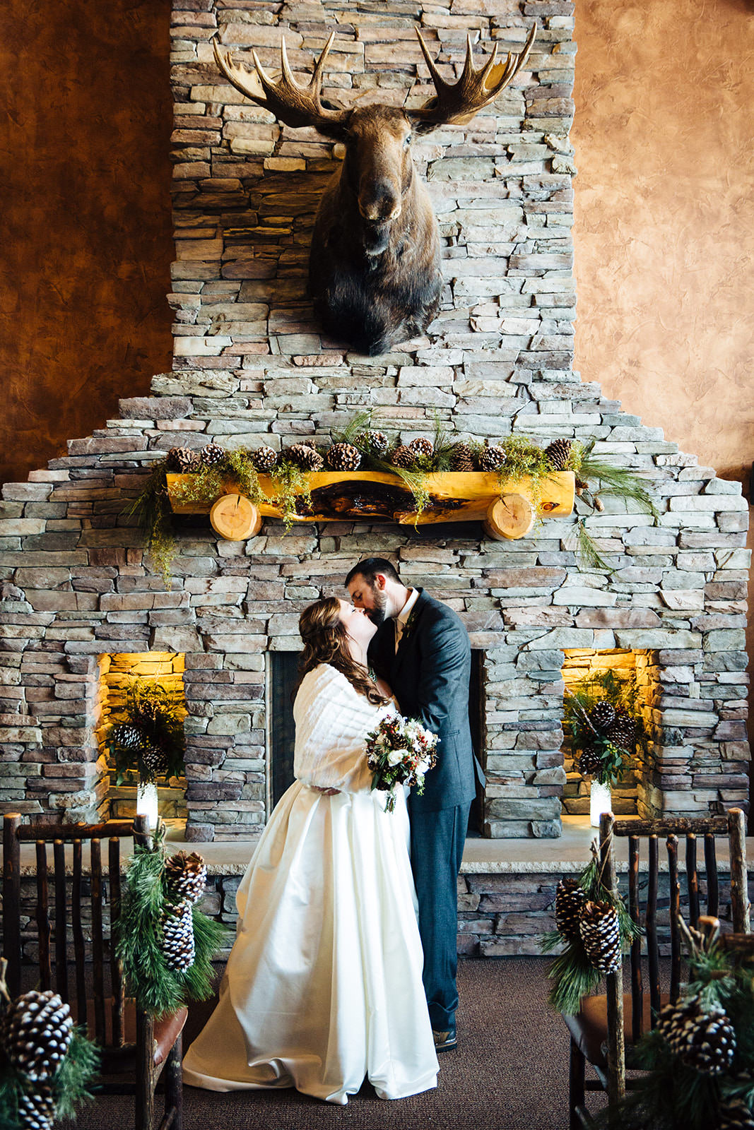 Couple kissing in front of the stone fireplace at Whitefish Lodge — Tim Larsen Photography, Brainerd Lakes MN