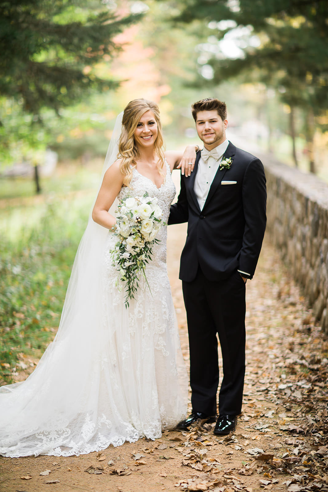 Couple editorial portrait on the stone wall path at Whitefish Lodge — Tim Larsen Photography, Brainerd Lakes MN