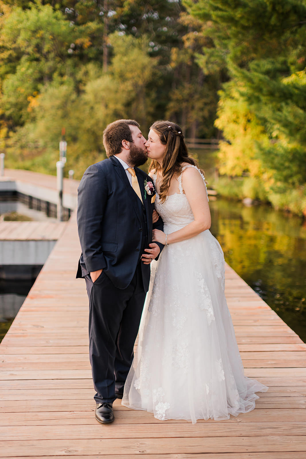 Couple kissing on the dock at Whitefish Lodge — fall color and water reflection — Tim Larsen Photography, Brainerd Lakes MN