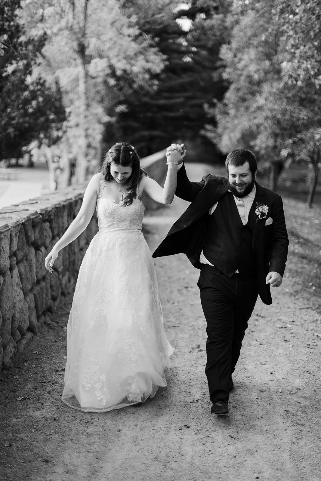 Couple walking hand in hand along the stone wall path at Whitefish Lodge — Tim Larsen Photography, Brainerd Lakes MN