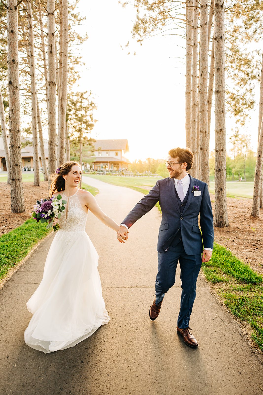Symmetrical pine corridor with backlit couple walking center frame at golden hour. — Tim Larsen Photography, Brainerd Lakes MN
