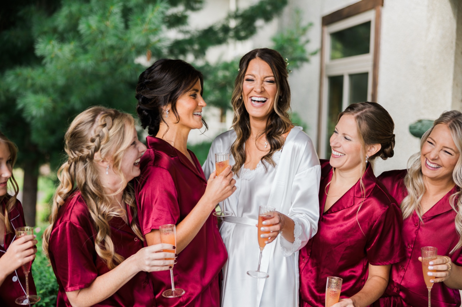 Bride in white robe laughs with bridesmaids in burgundy satin outside Manhattan Beach Lodge — Tim Larsen Photography, Brainerd Lakes MN