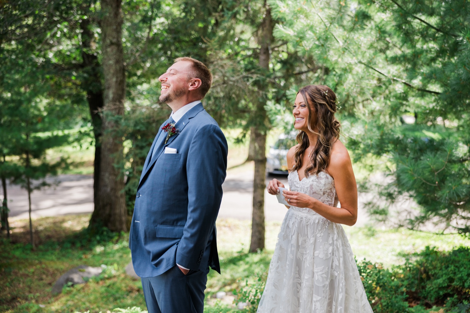 Bride and groom laugh together on a wooded path reading private vows near Manhattan Beach Lodge — Tim Larsen Photography, Brainerd Lakes MN
