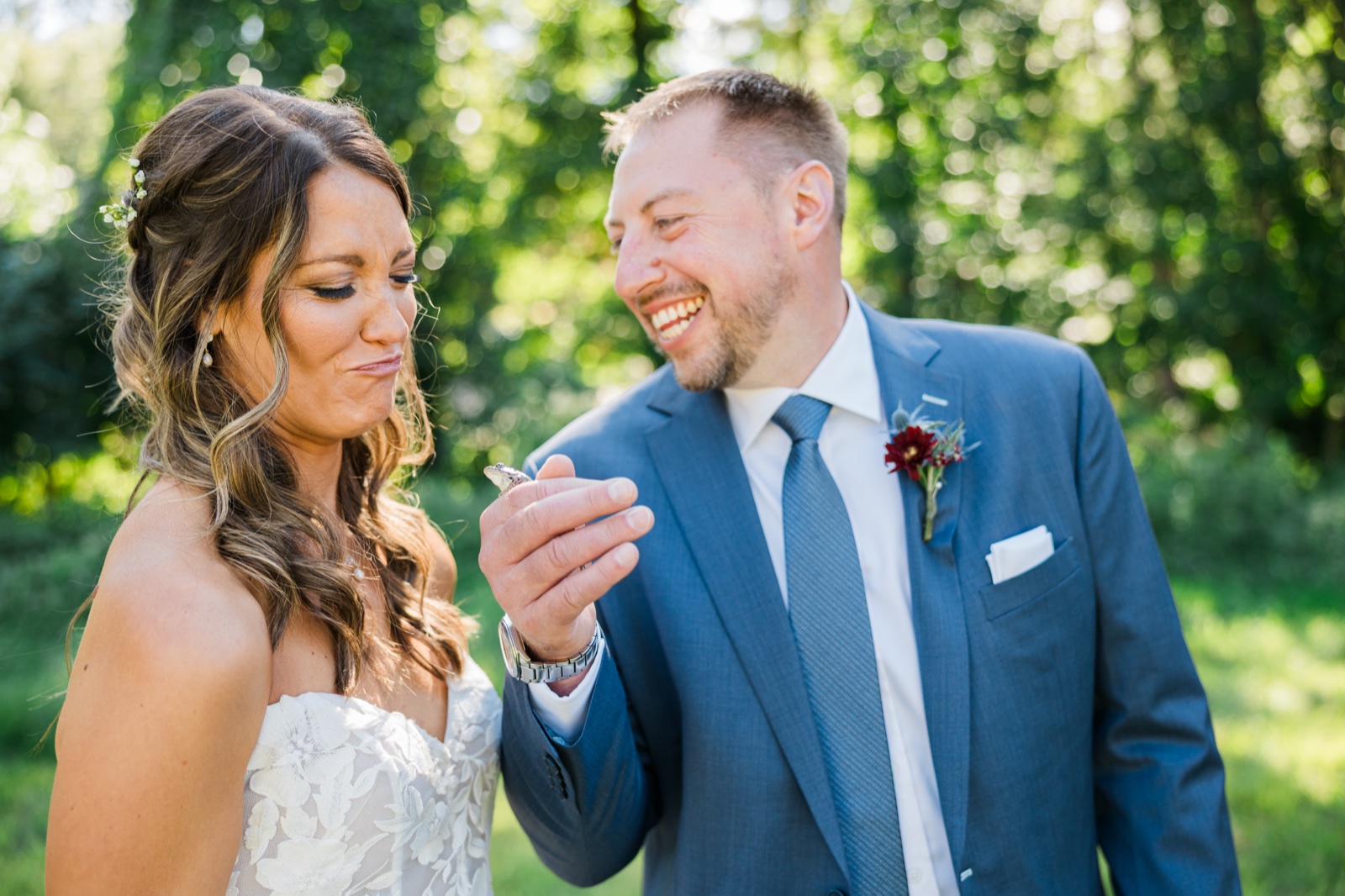 Groom holds a small frog up to the bride, who makes a squeamish face, between portraits at Manhattan Beach Lodge — Tim Larsen Photography, Brainerd Lakes MN