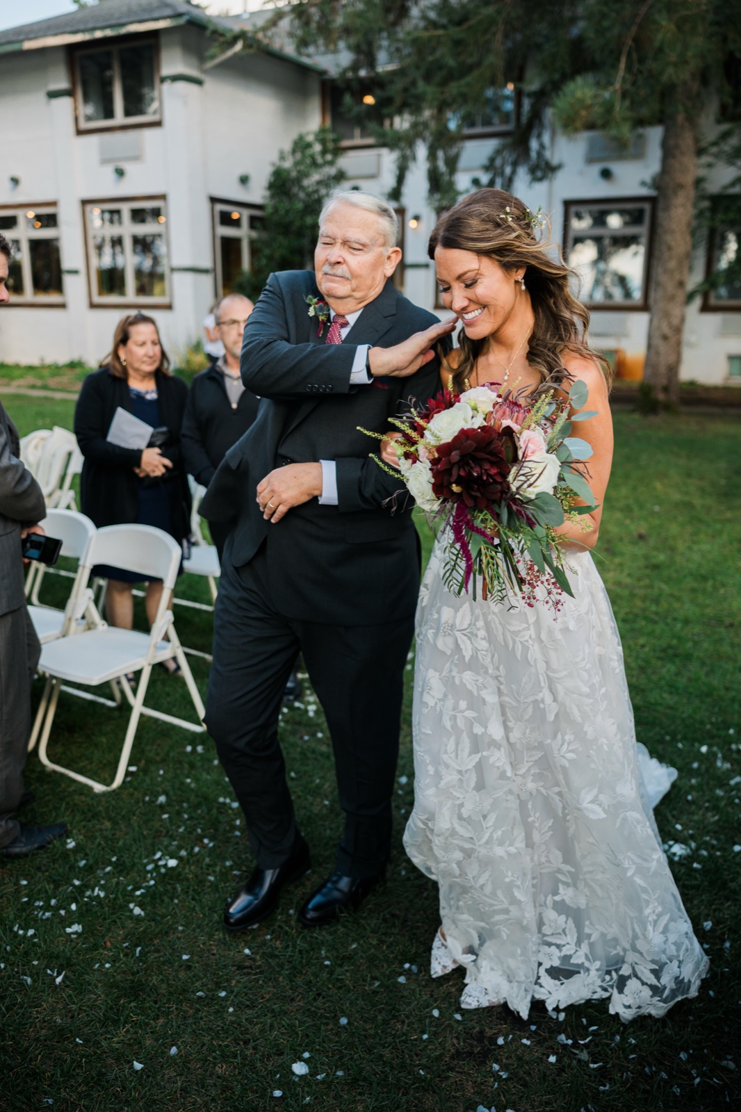 Father wipes a tear from the brides cheek as they walk the aisle outside Manhattan Beach Lodge — Tim Larsen Photography, Brainerd Lakes MN