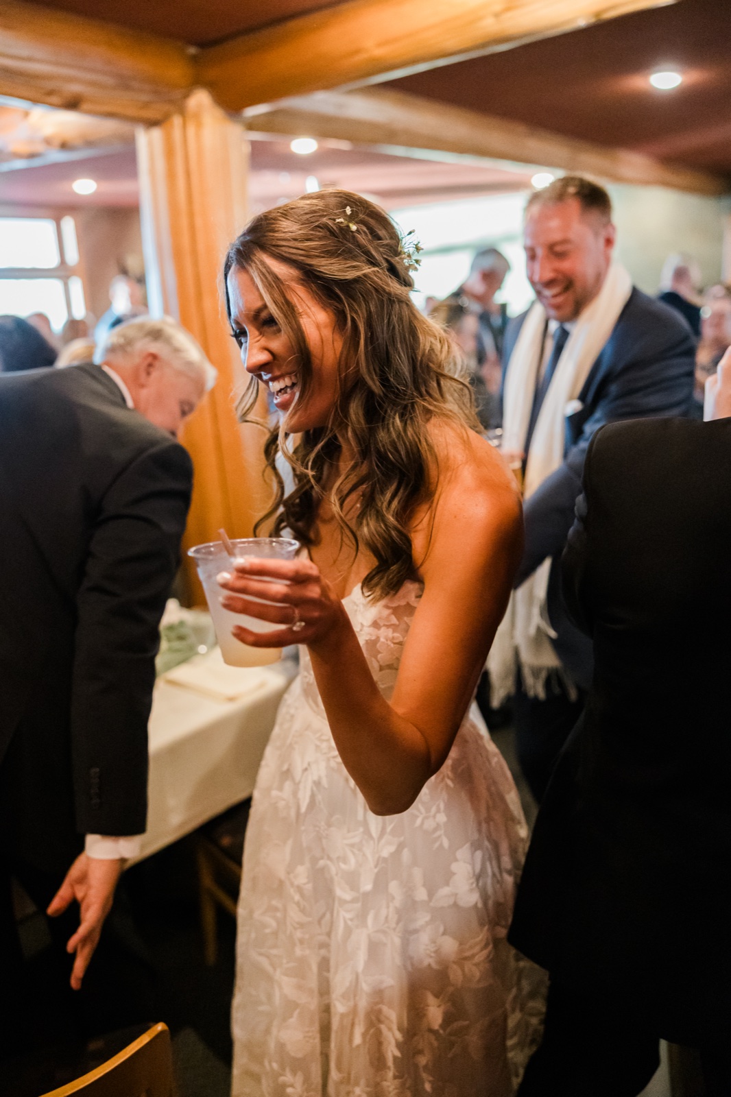 Bride laughs with a cocktail in hand during cocktail hour at Manhattan Beach Lodge — Tim Larsen Photography, Brainerd Lakes MN