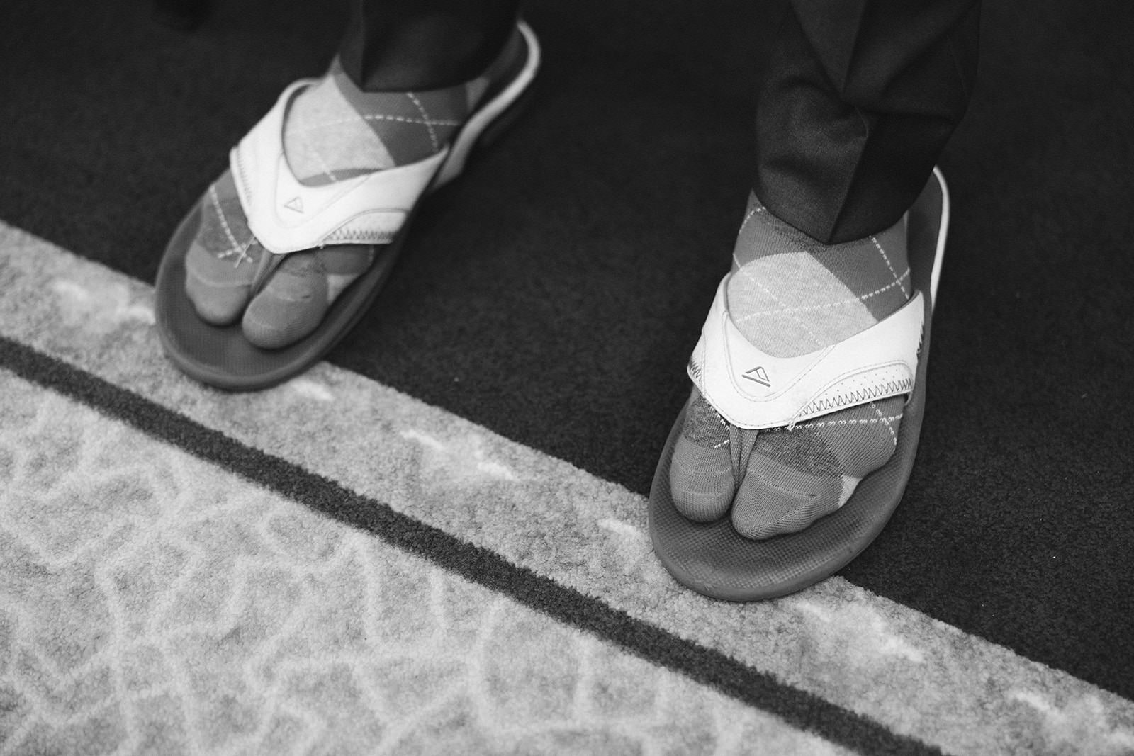 Black and white detail of two pairs of argyle flip-flops before the ceremony — Tim Larsen Photography, Brainerd Lakes MN