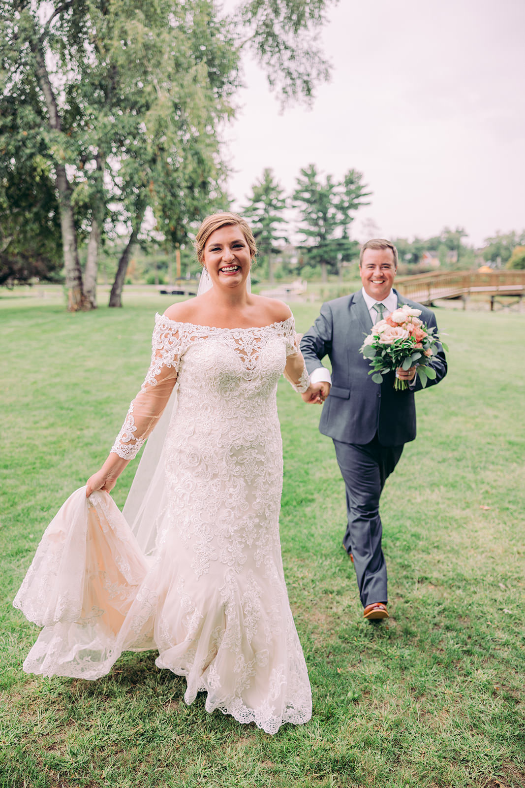 Couple walking through birch trees on the resort grounds, bride trailing her train — Tim Larsen Photography, Brainerd Lakes MN