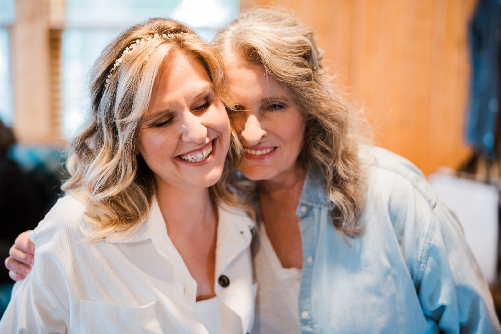 Bride and her mother cheek-to-cheek in a quiet moment before the dress goes on — Tim Larsen Photography, Brainerd Lakes MN