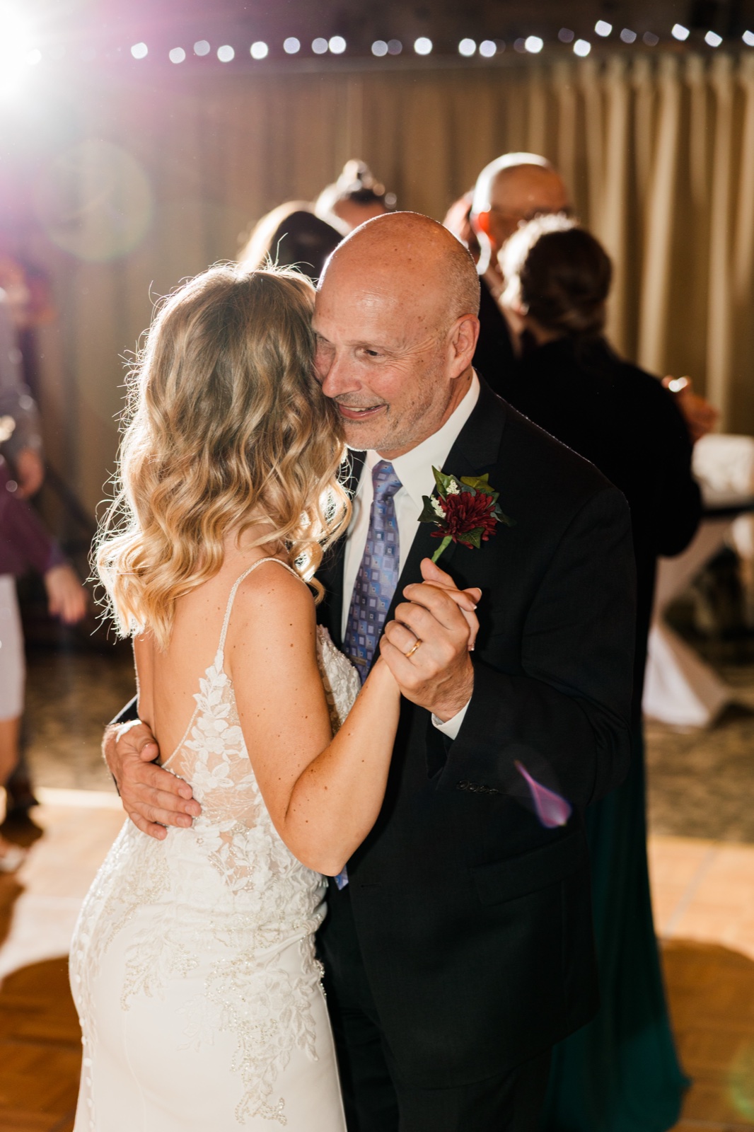 Bride and her father dancing cheek-to-cheek under string lights at the Madden's reception
