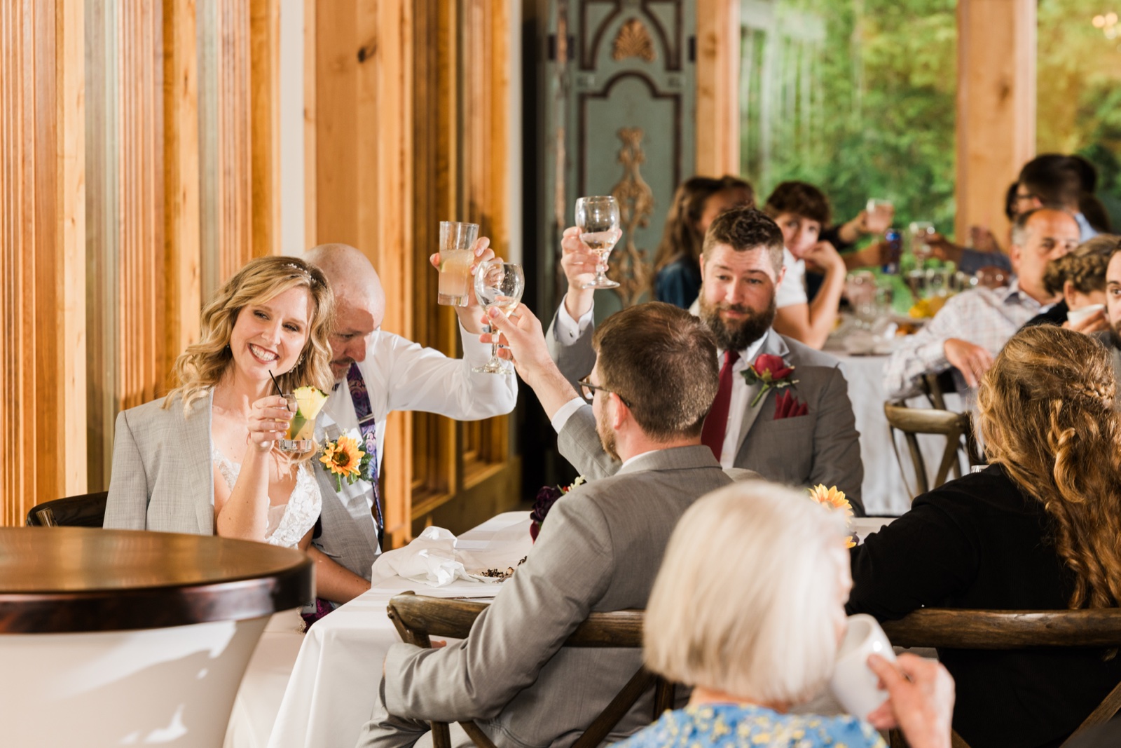 Bride smiling during a toast as the whole room raises their glasses inside the Madden's pavilion