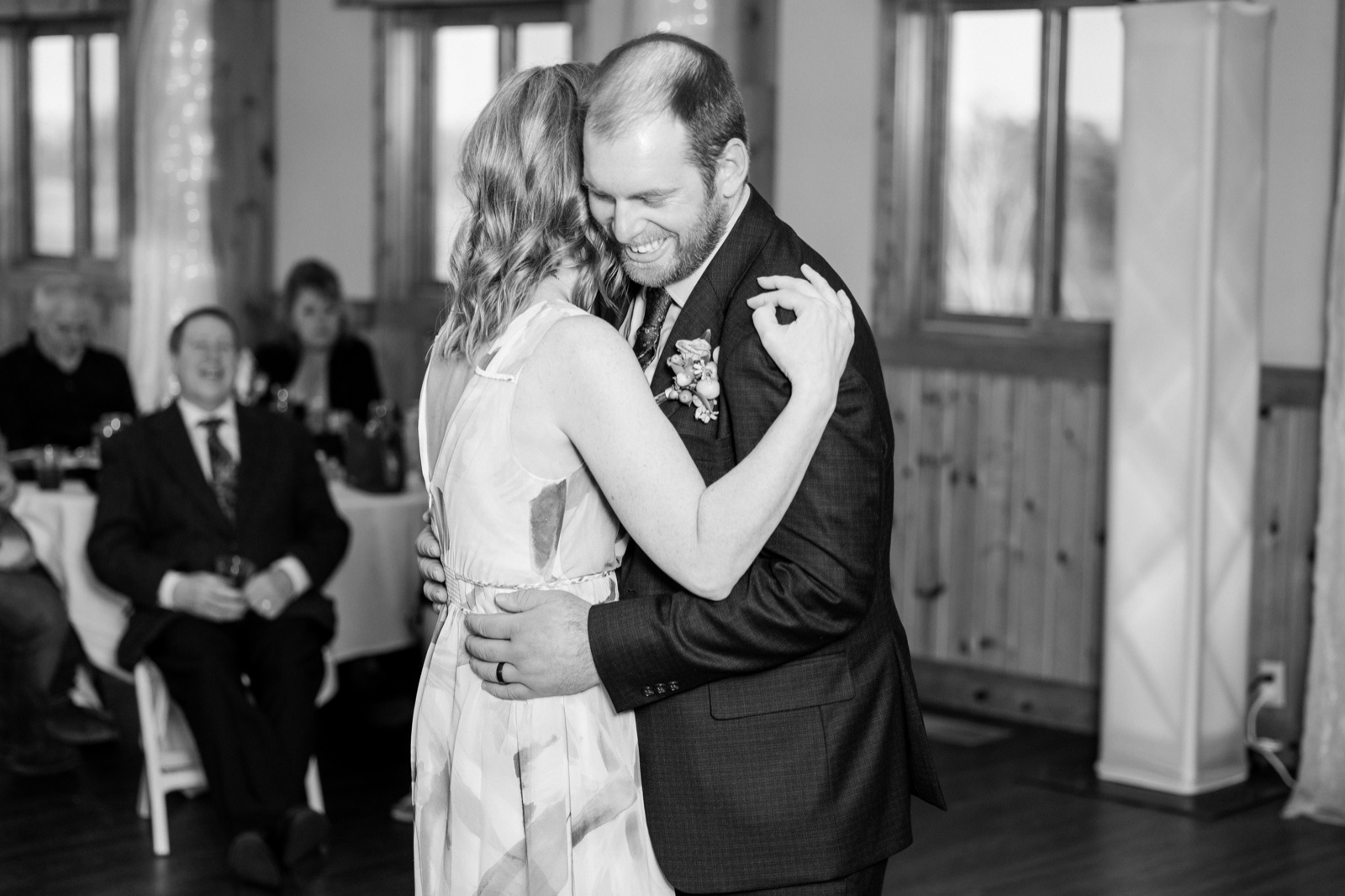 The groom grins with eyes closed as he embraces the bride during their first dance at Cragun's Resort — Tim Larsen Photography, Brainerd Lakes MN