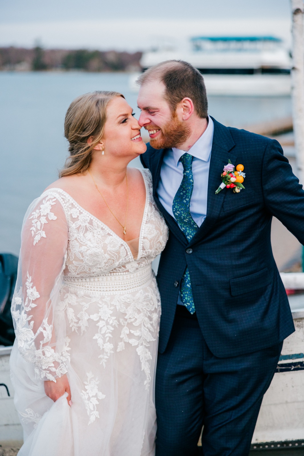 The bride and groom lean foreheads together and laugh on a lakeside dock at Cragun's, a paddleboat visible on Gull Lake behind them — Tim Larsen Photography, Brainerd Lakes MN